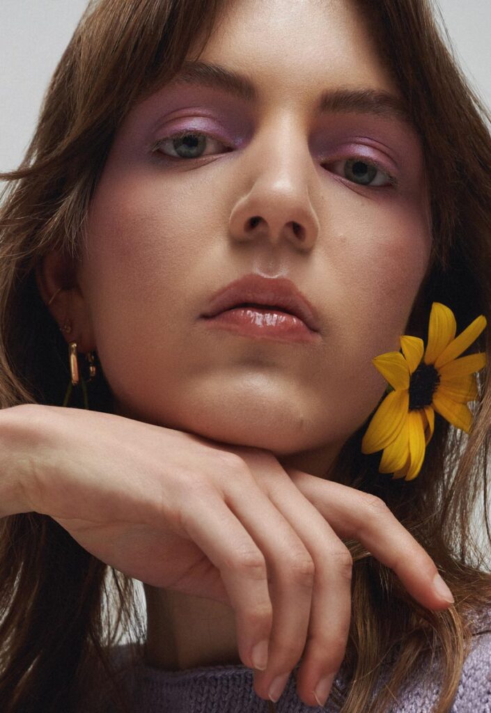 Pastell-Lidschatten in Fliedertönen, glossige Lippen und gelbe Blüte – Kreativübung aus der Online Make-up Ausbildung, ideal fürs Portfolio.